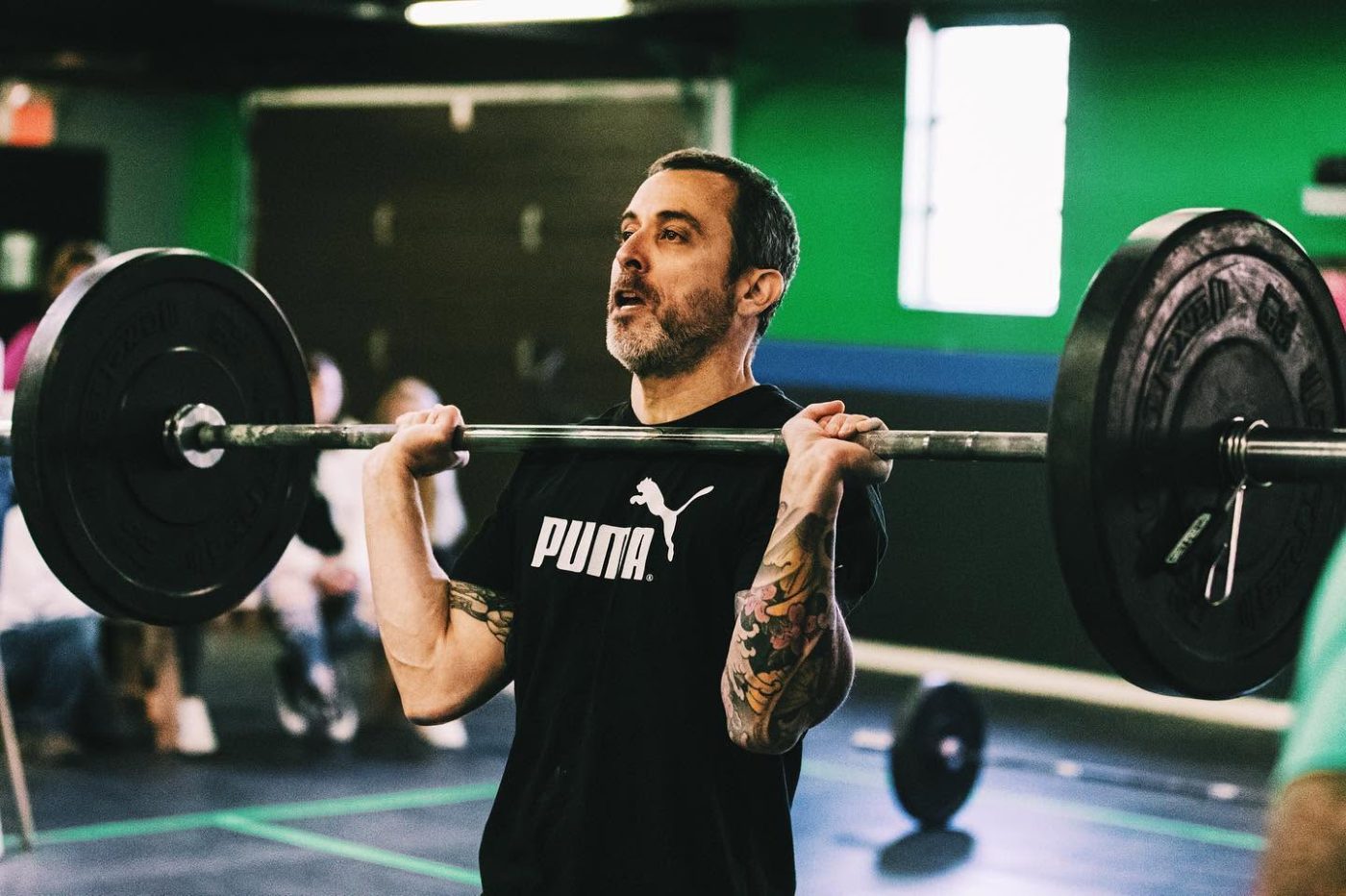 A masters athlete standing up a clean in competition